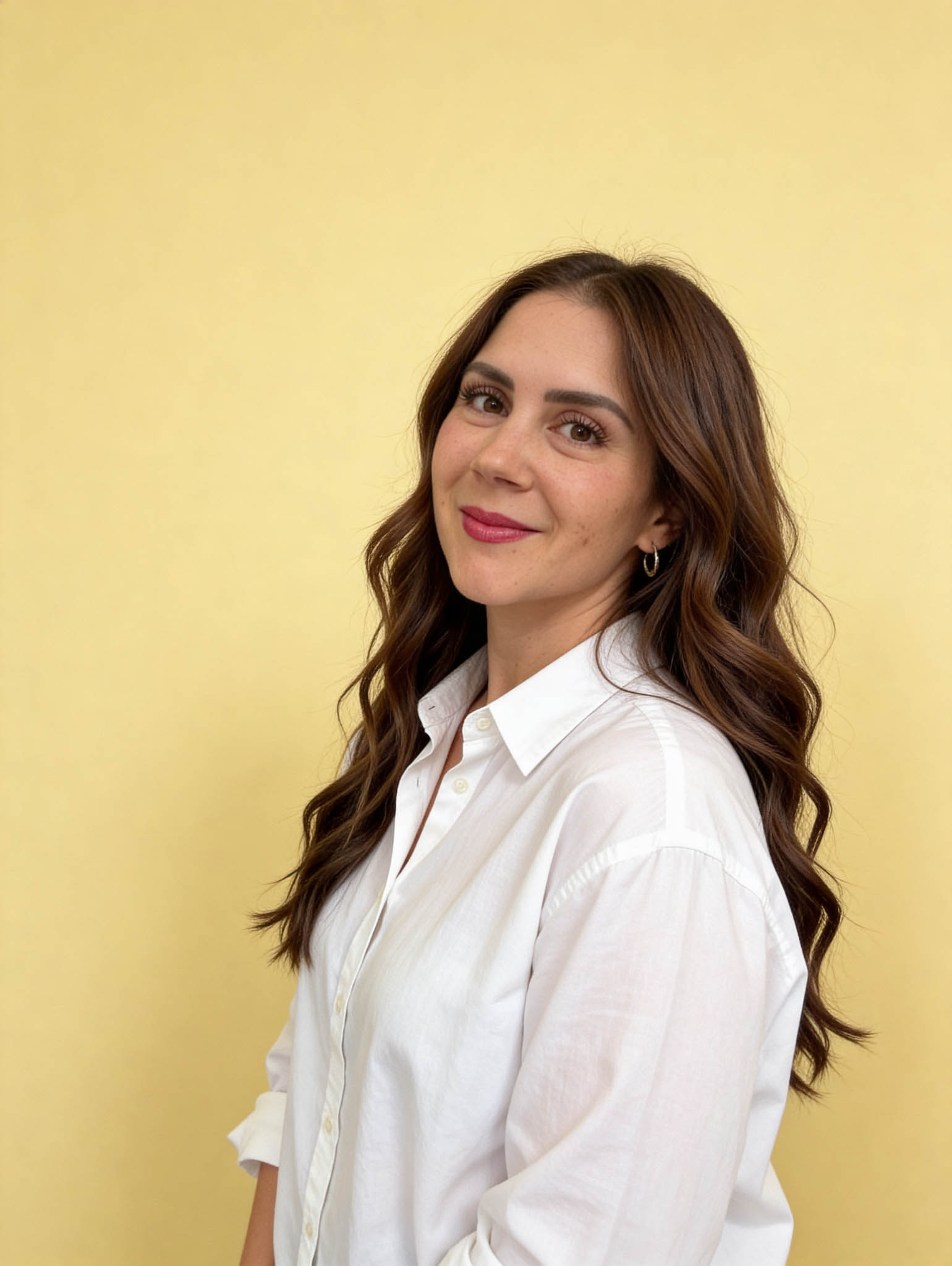 Liz McVoy, founder of Lucera Studio, standing in front of a yellow backdrop.
